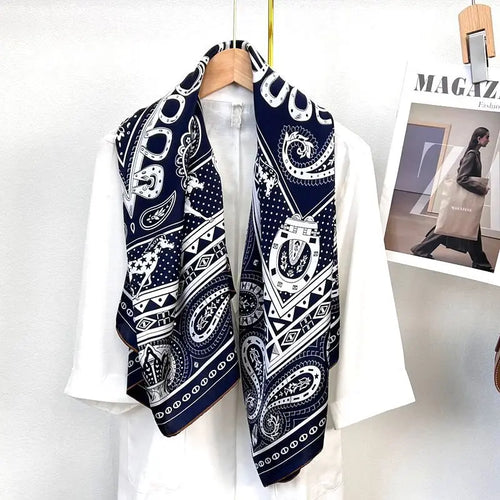 Luxury navy blue and white silk scarf with paisley, horseshoe, and star equestrian motifs in a long rectangular shape.