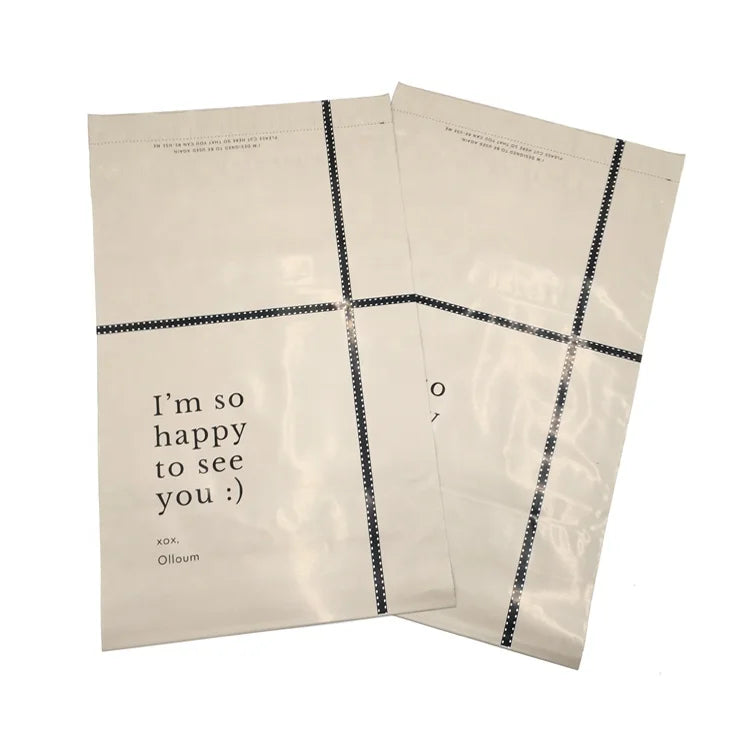 Cream poly mailer envelopes with black grid border and printed "I'm so happy to see you"