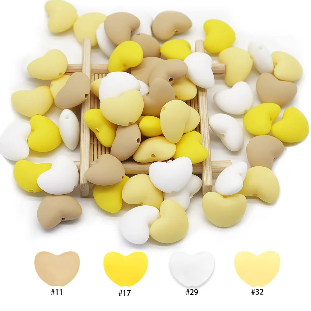Yellow, white, and tan heart silicone teething toy beads for baby teething relief.