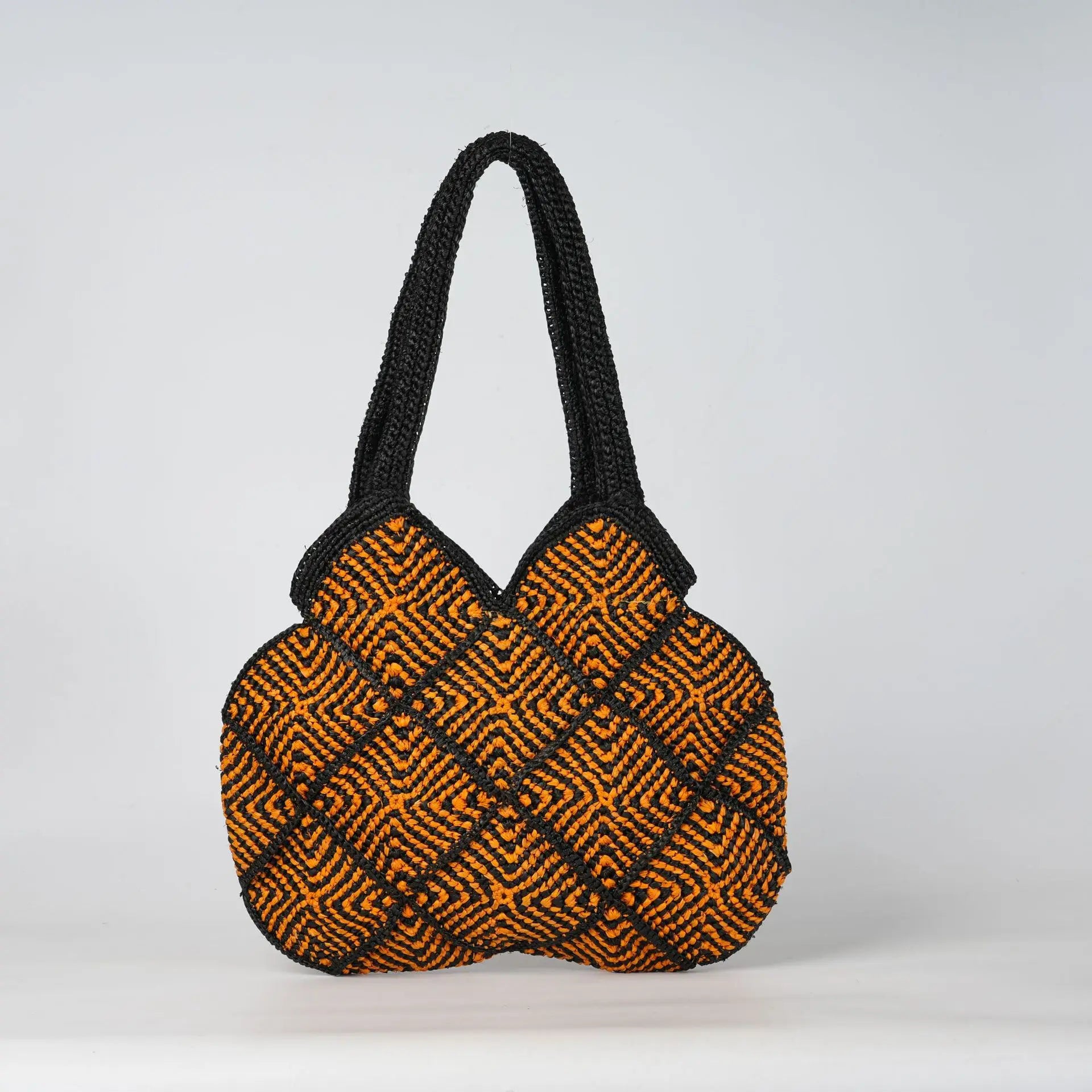 Boho crochet tote bag in black and orange geometric pattern with sturdy handles, perfect for daily or beach use.