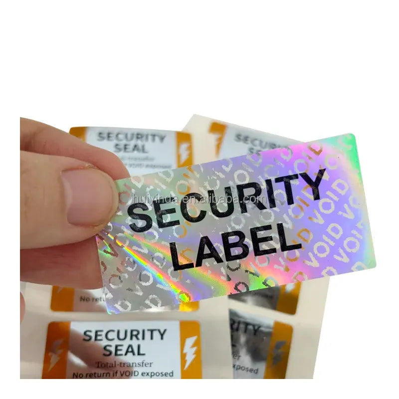 Security label stickers with VOID pattern, hand holding one iridescent seal