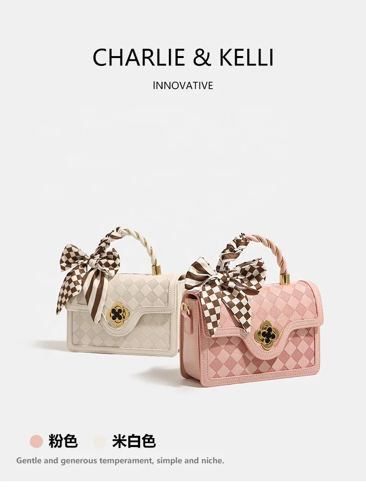 Pink and white plaid leather trunk handbags with checkered bow accents, top handles, and gold clover-style clasps.