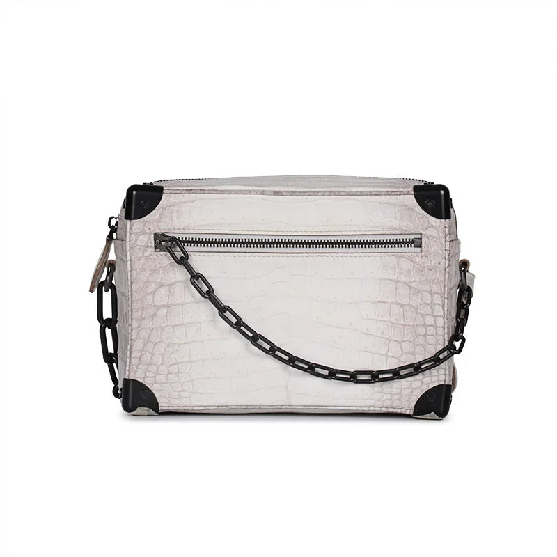 White Himalayan crocodile leather trunk handbag with black metal corners and matching decorative link chain strap.