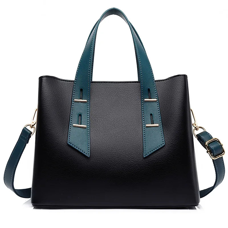 Black designer leather handbag with teal handles, crossbody strap, and gold hardware accents.