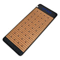 Rectangular infrared therapy mat with tan natural stone tiles, black trim, and embedded black crystals for heat therapy.