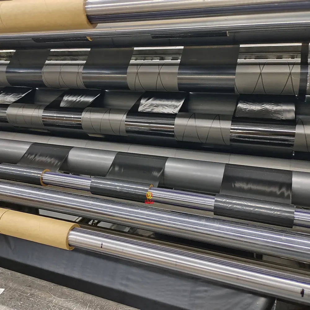 Printed label sticker rolls on dispenser, silver sheets with small orange logo