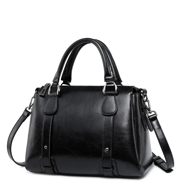 Black genuine leather top handle satchel handbag with dual straps, silver hardware, and adjustable shoulder strap.