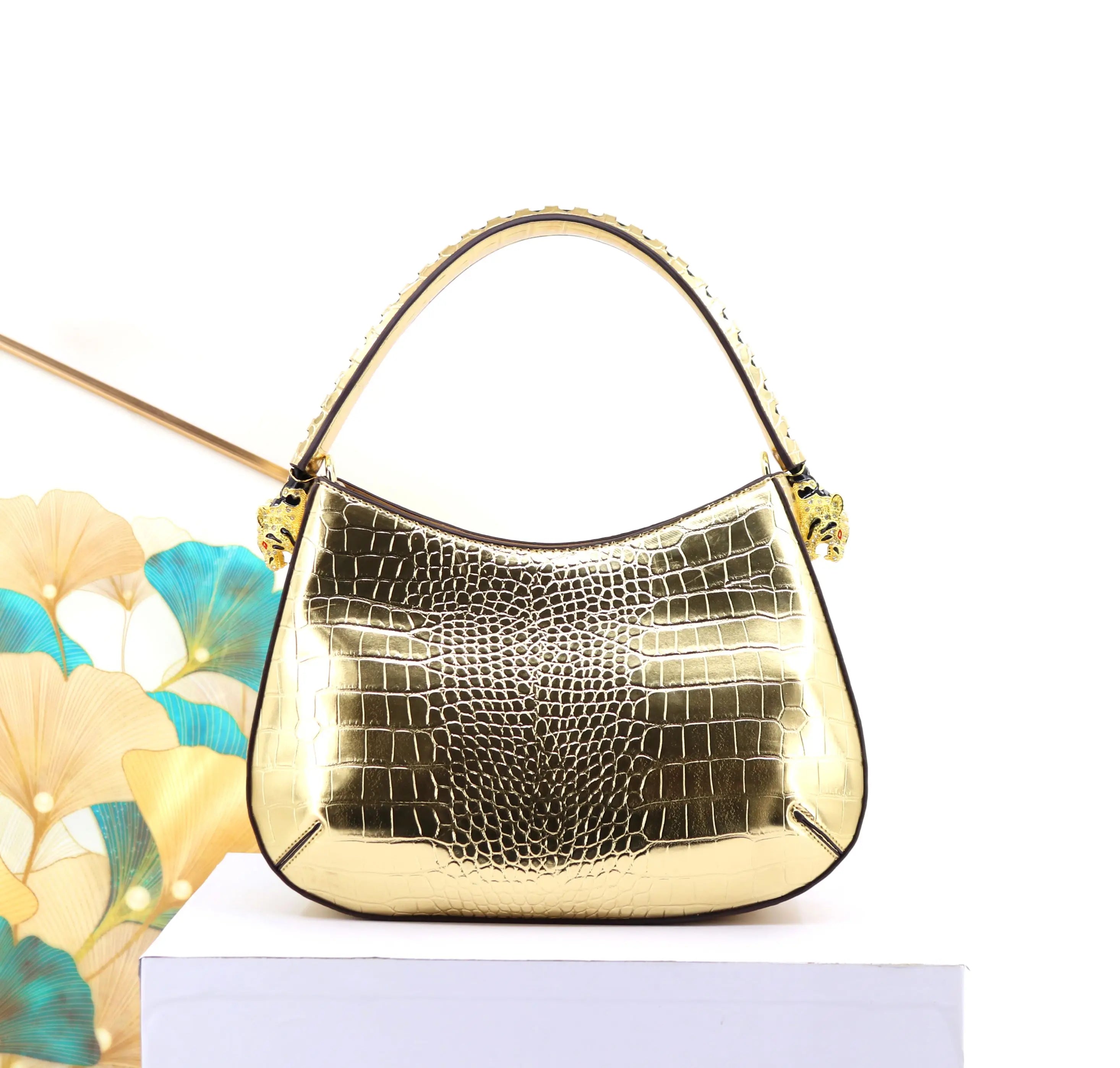 32cm gold metallic crocodile-embossed leather designer shoulder bag with decorative feline head hardware accents.