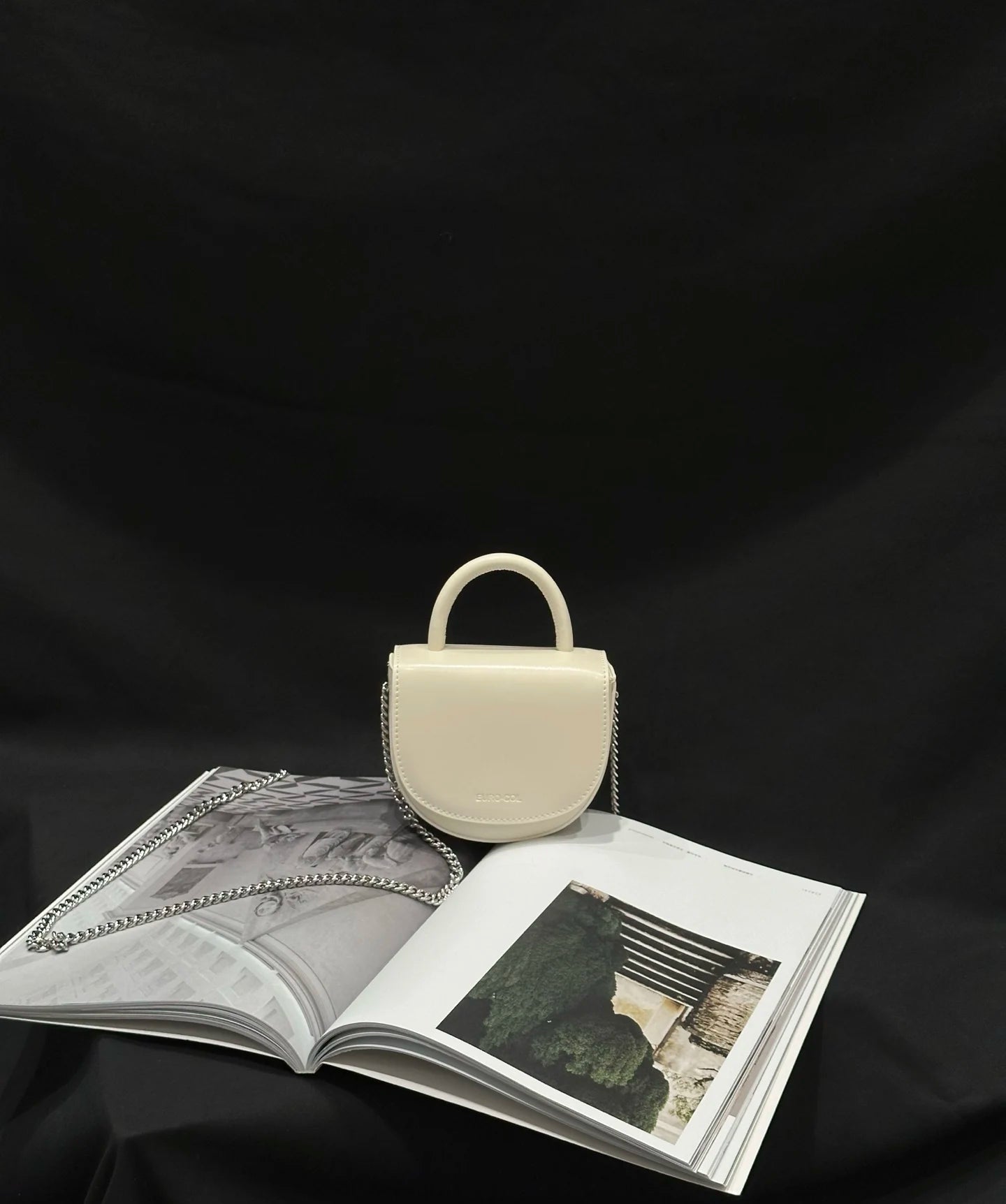 Cream cowhide leather mini top-handle evening bag with a silver chain strap, perfect for weddings or party wear.