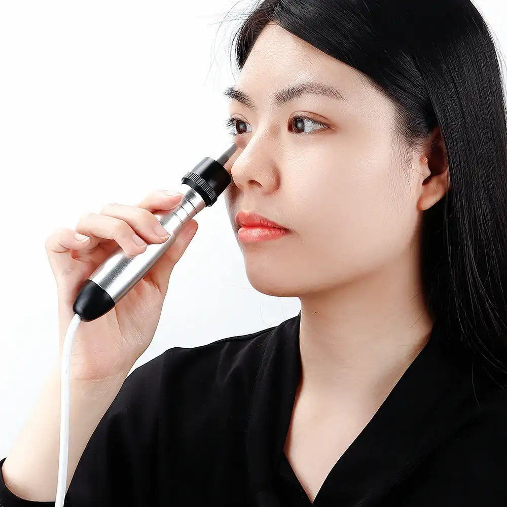 A woman using a handheld, silver and black RF skin-tightening wand on the area under her eye.