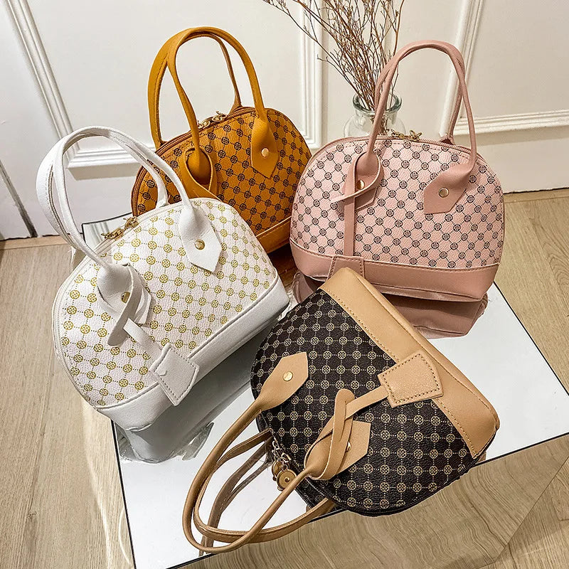 Designer handbags: set of four shell-shaped shoulder bags with geometric print, zipper closure, and top handles.