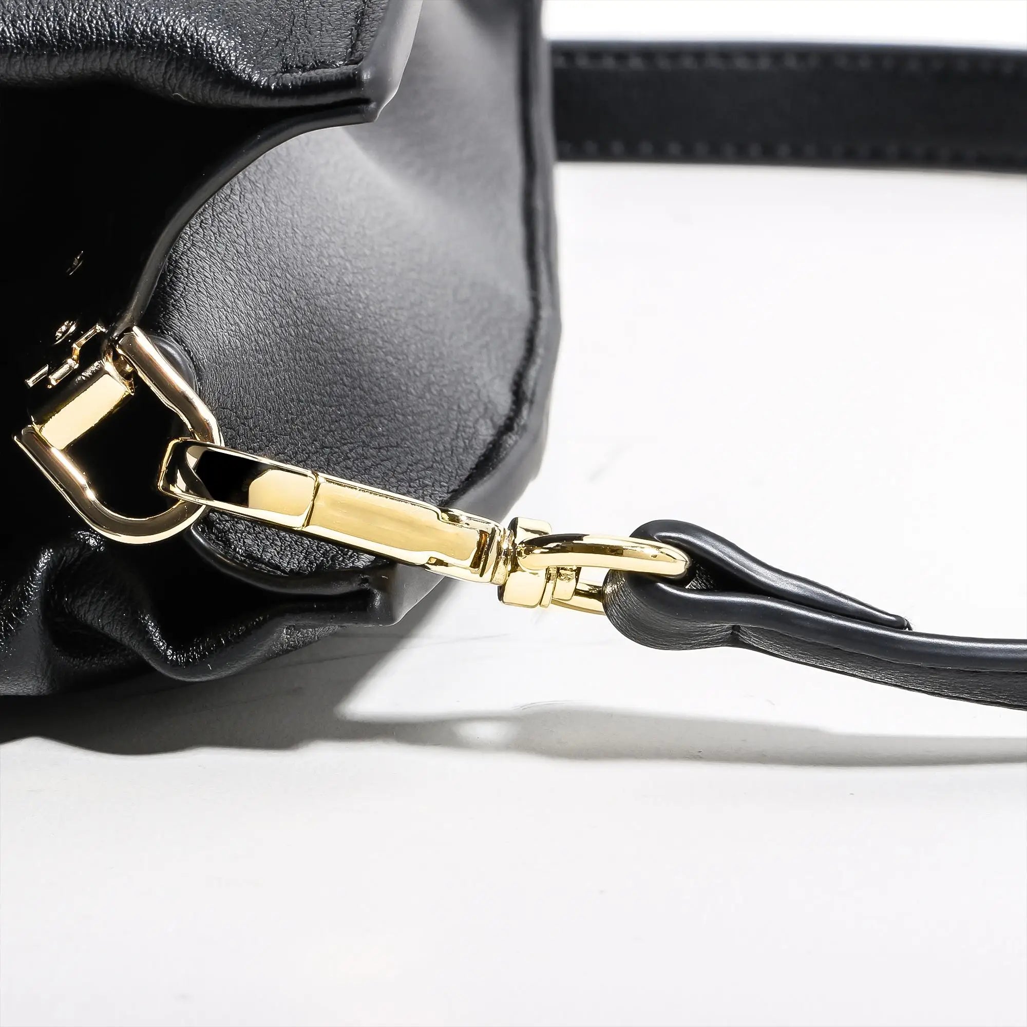 Black genuine leather work tote with gold-tone hardware and detachable crossbody strap. Durable, water-resistant style.