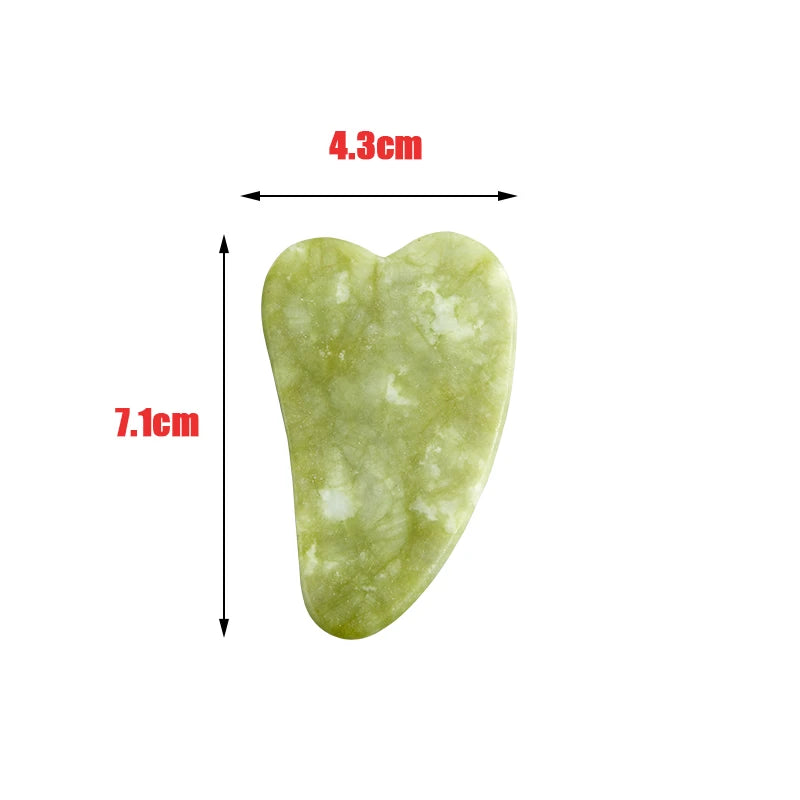 Heart-shaped light green jade gua sha facial tool with measurement indicators showing 7.1cm height and 4.3cm width.