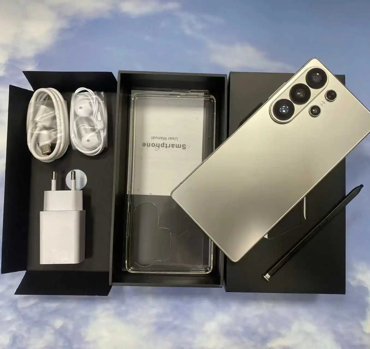 Silver smartphone bundle with box contents: phone, charging cable, earbuds, and SIM tool.