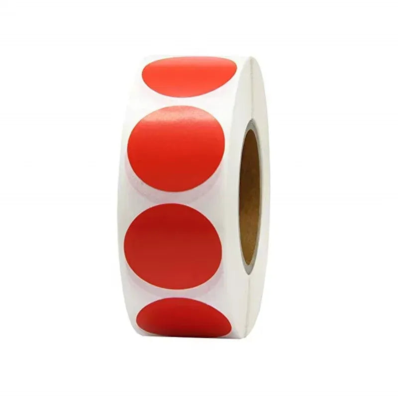 Red circular sticker label roll on white backing, side view