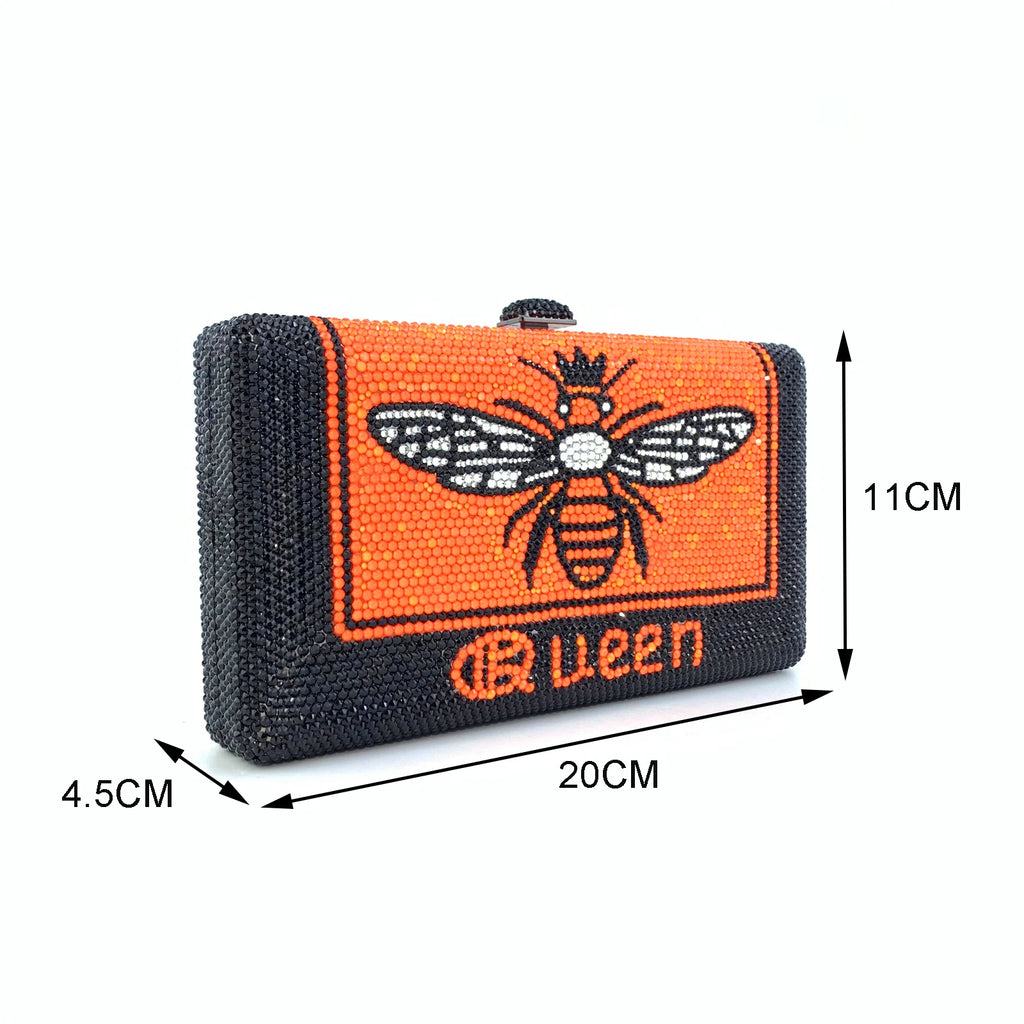 Black and orange rhinestone hard shell evening clutch with bee motif and "Queen" text. Designer handbag style.
