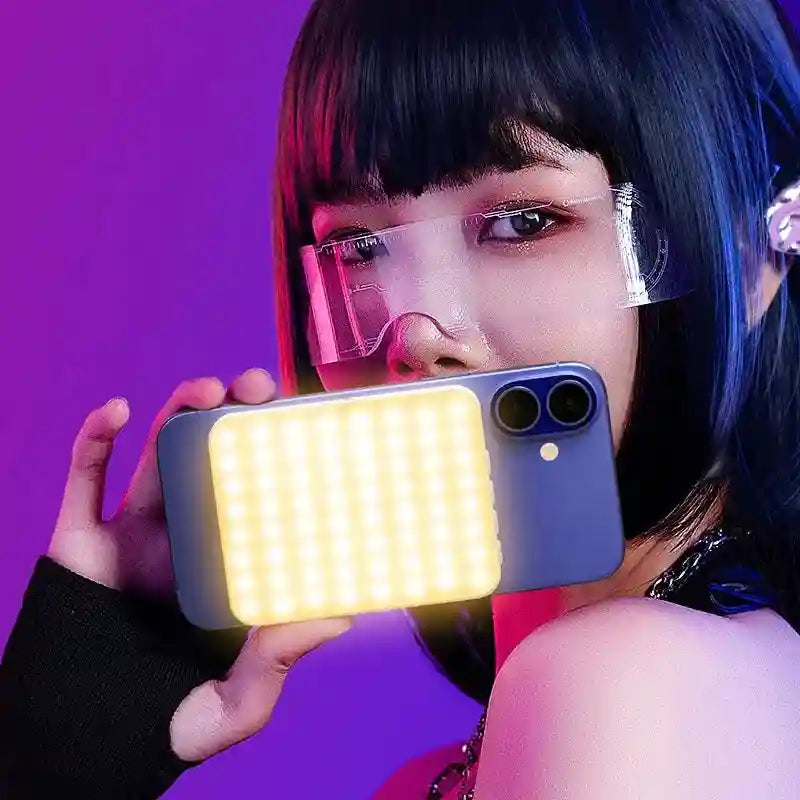 Square LED fill light attached to a smartphone for portable, warm lighting during photography or video calls.