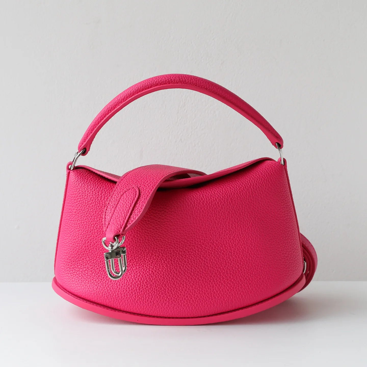 Hot pink cowhide leather pillow handbag, luxury designer crossbody bag with magnetic closure and dual carry straps.