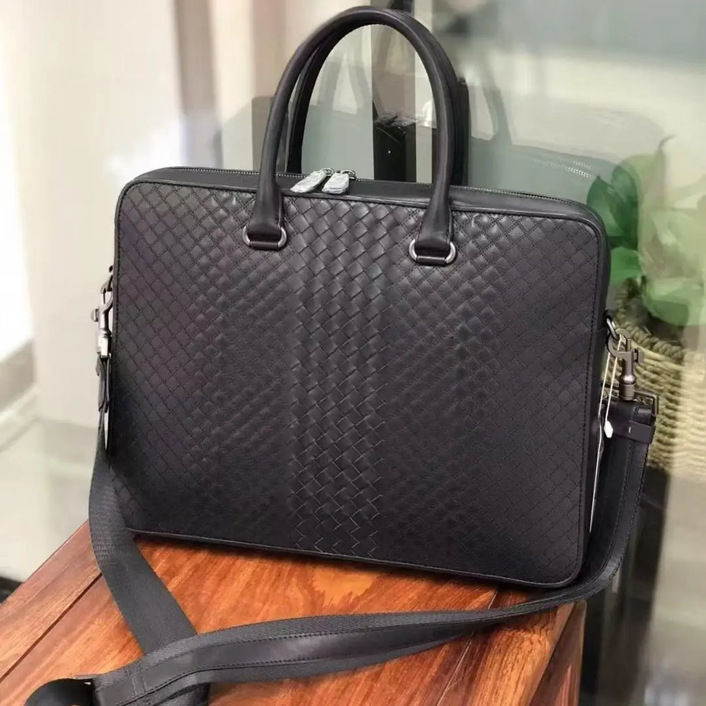 Luxury black waxed calfskin slim laptop briefcase with woven leather pattern and detachable shoulder strap.