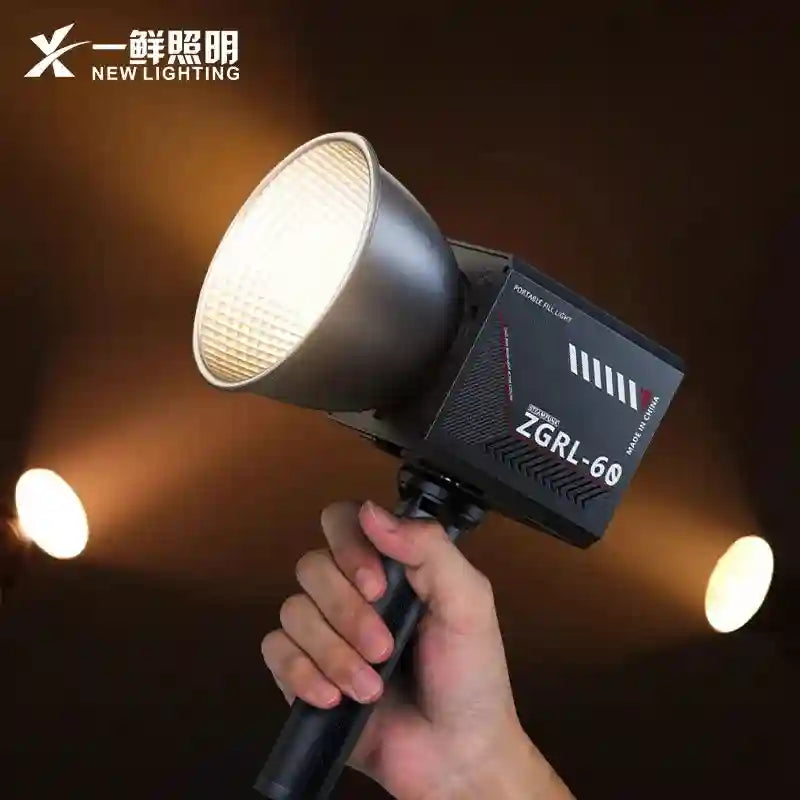 Handheld ZGRL-60 portable fill light with a black boxy body and a silver bowl-shaped reflector for photography lighting.