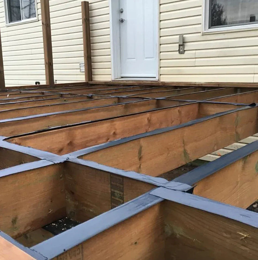 Black tape strips sealing wooden joists on a deck frame grid