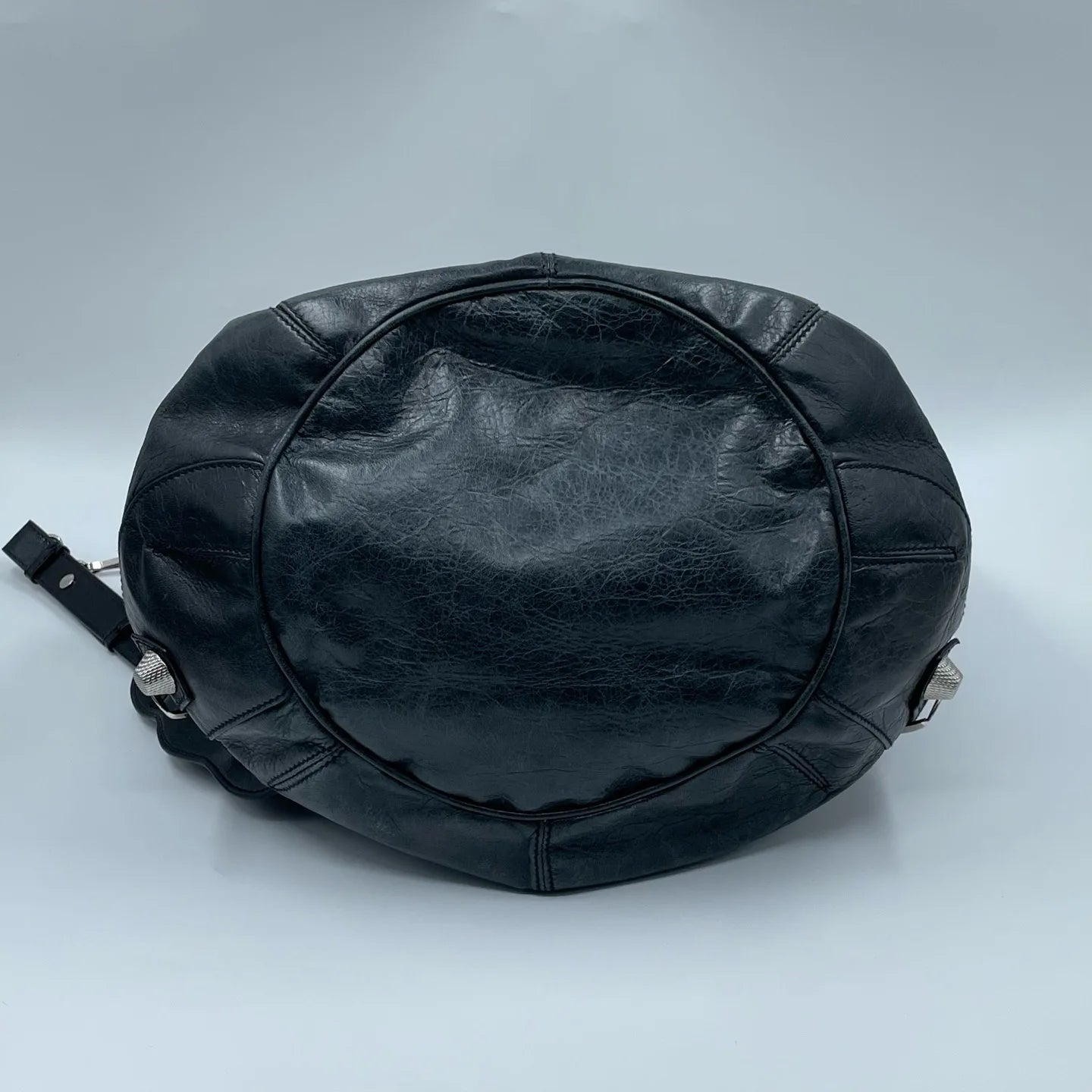 Pre-owned black leather designer bucket bag with textured finish, silver metal studs, and adjustable shoulder strap.