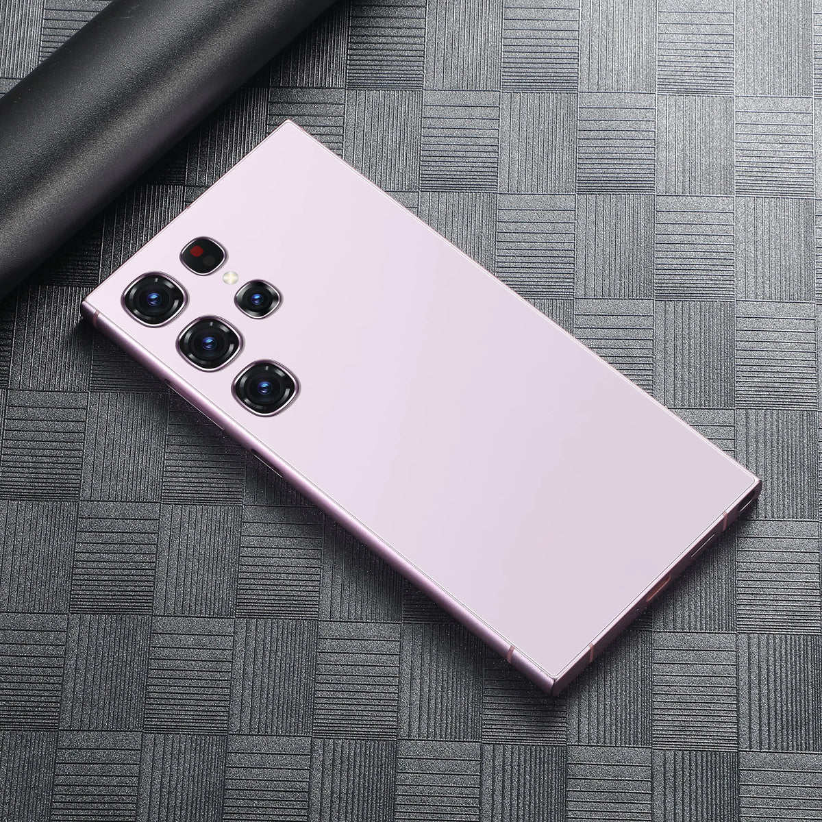Pink smartphone back with quad rear cameras on a gray textured surface