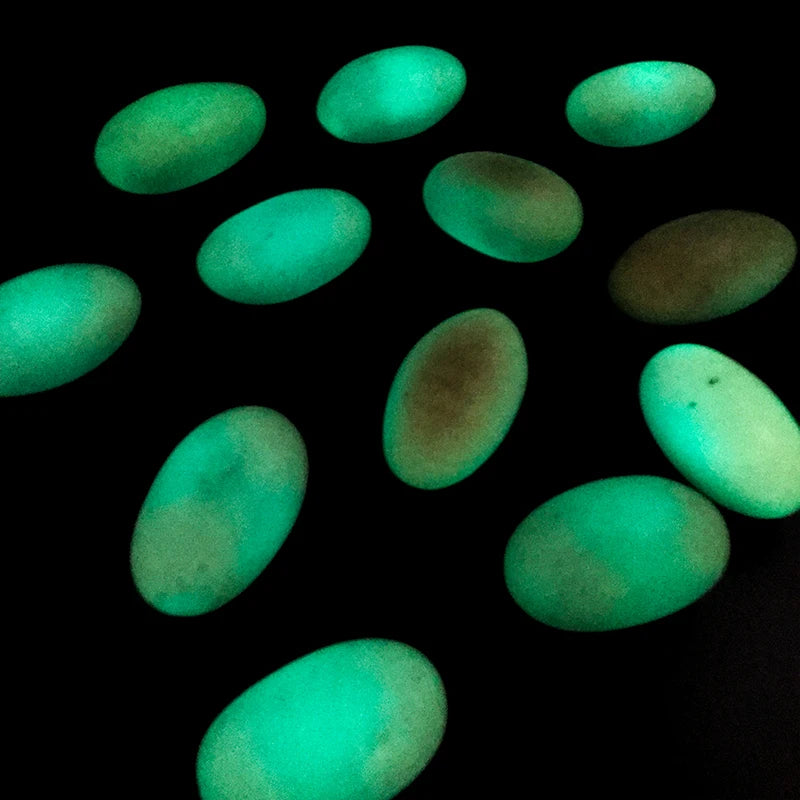 Glowing green oval crystal pebbles on dark background, luminous landscaping stones