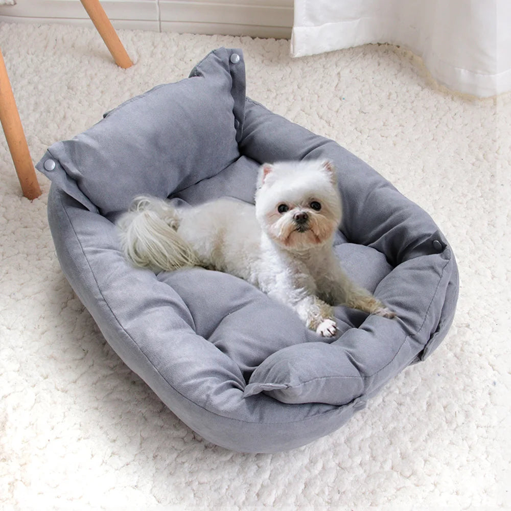 Small white dog relaxing on a plush, grey rectangular dog sofa bed, perfect for warm and cozy winter pet comfort.