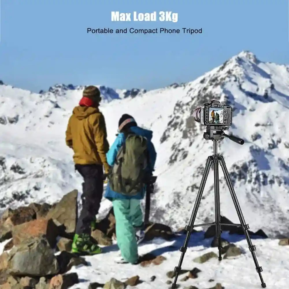 Black adjustable tripod holding a digital camera on a snowy mountain for outdoor photography.