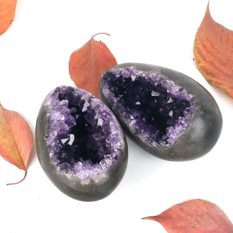 Pair of amethyst crystal geode eggs with purple sparkle interiors