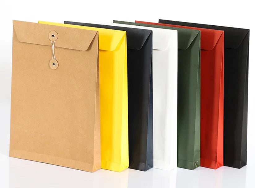 Assorted kraft paper mailing pouches in multiple colors with snap-button closures