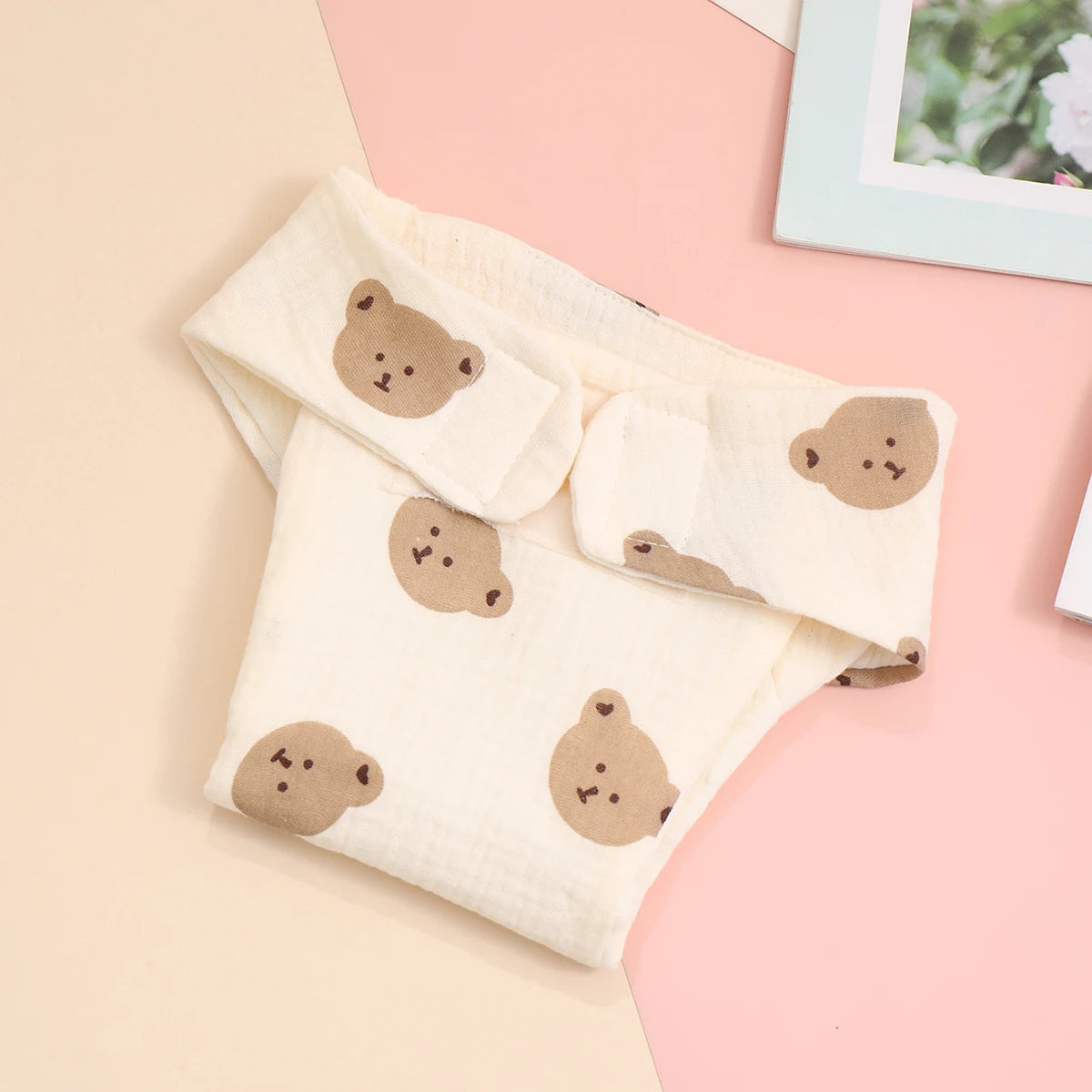 Soft cotton reusable baby diaper cover featuring a cute brown bear print on a cream background.