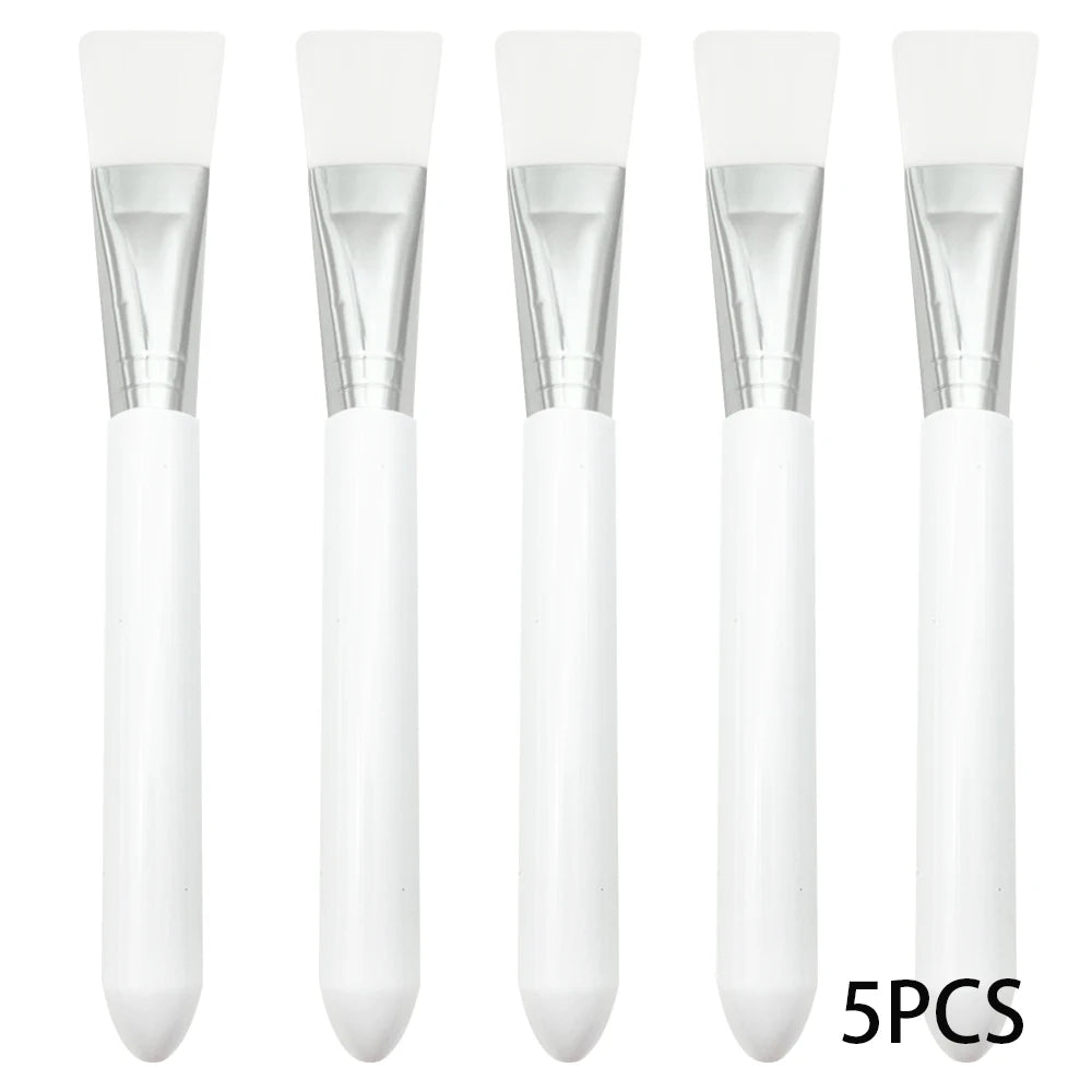 Five face mask applicator brushes with white silicone heads, silver ferrules, and smooth white handles.