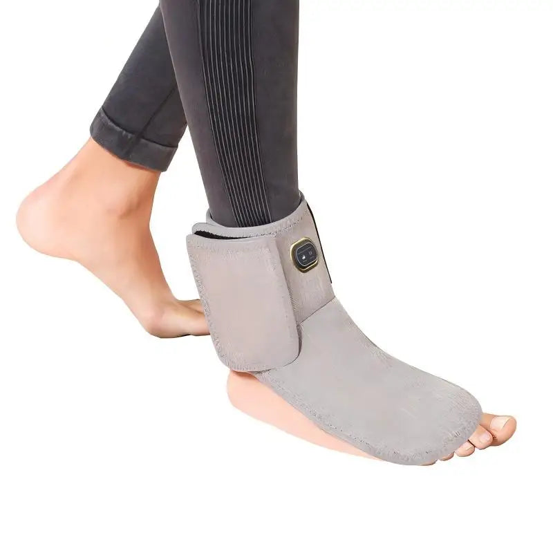 Grey heated ankle sleeve with red light therapy and vibration massage for foot pain relief on a person's foot.
