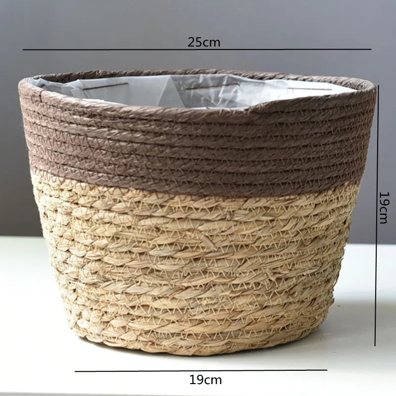 Woven grass planter basket with dark gray liner and pale tan weave, 19cm wide.