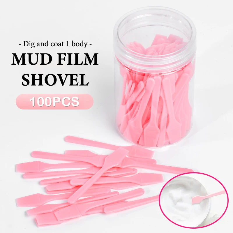 A set of 100 small, pink plastic cosmetic spatulas in a clear plastic jar, used for scooping creams and makeup.