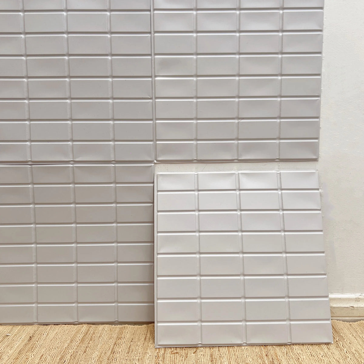 Peel-and-stick square backsplash tiles, glossy white raised grid pattern