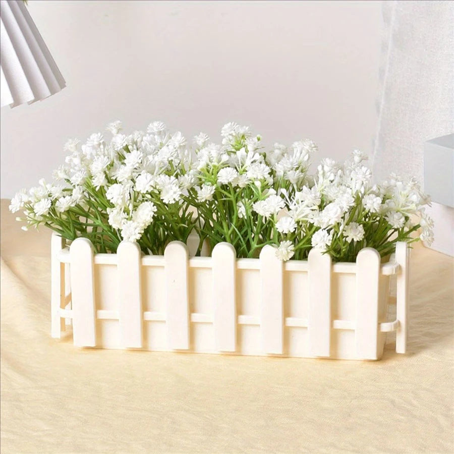 White rectangular planter pot with fence design, filled with white flowers and green stems