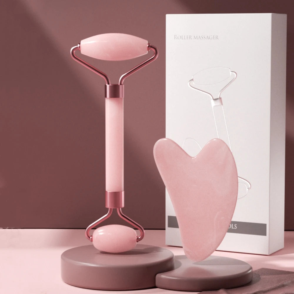 Pink dual-ended face roller and heart-shaped resin gua sha scraper with a white product box.