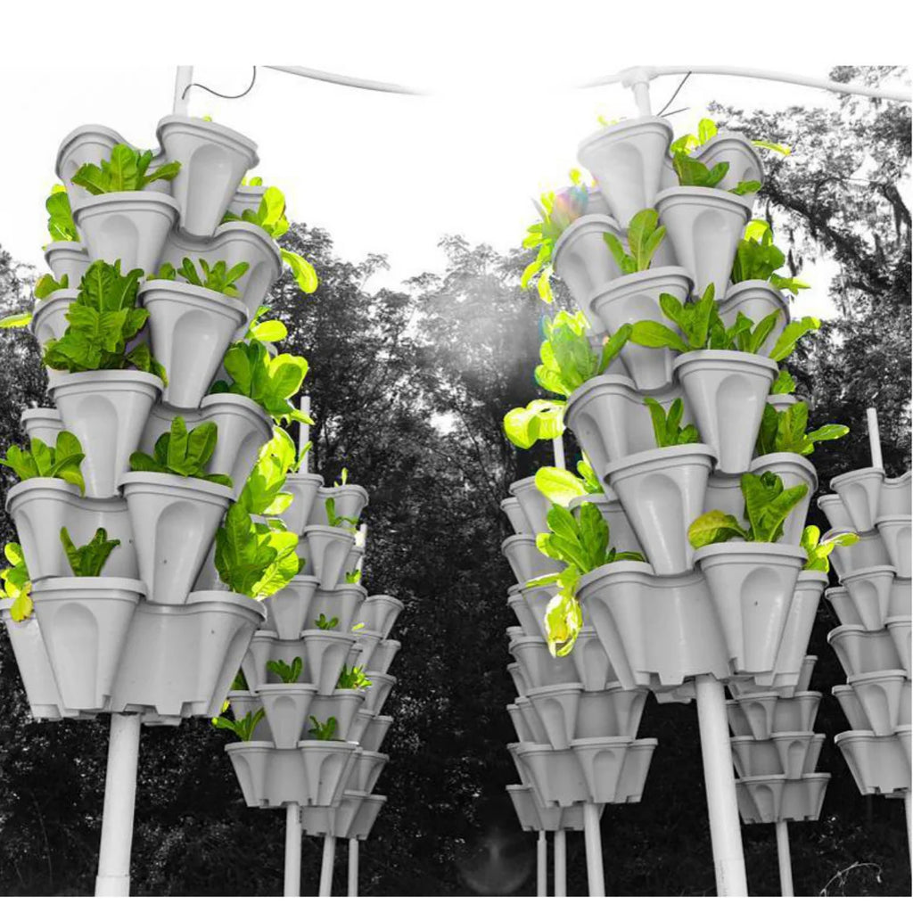 White stackable vertical planter pots holding leafy plants