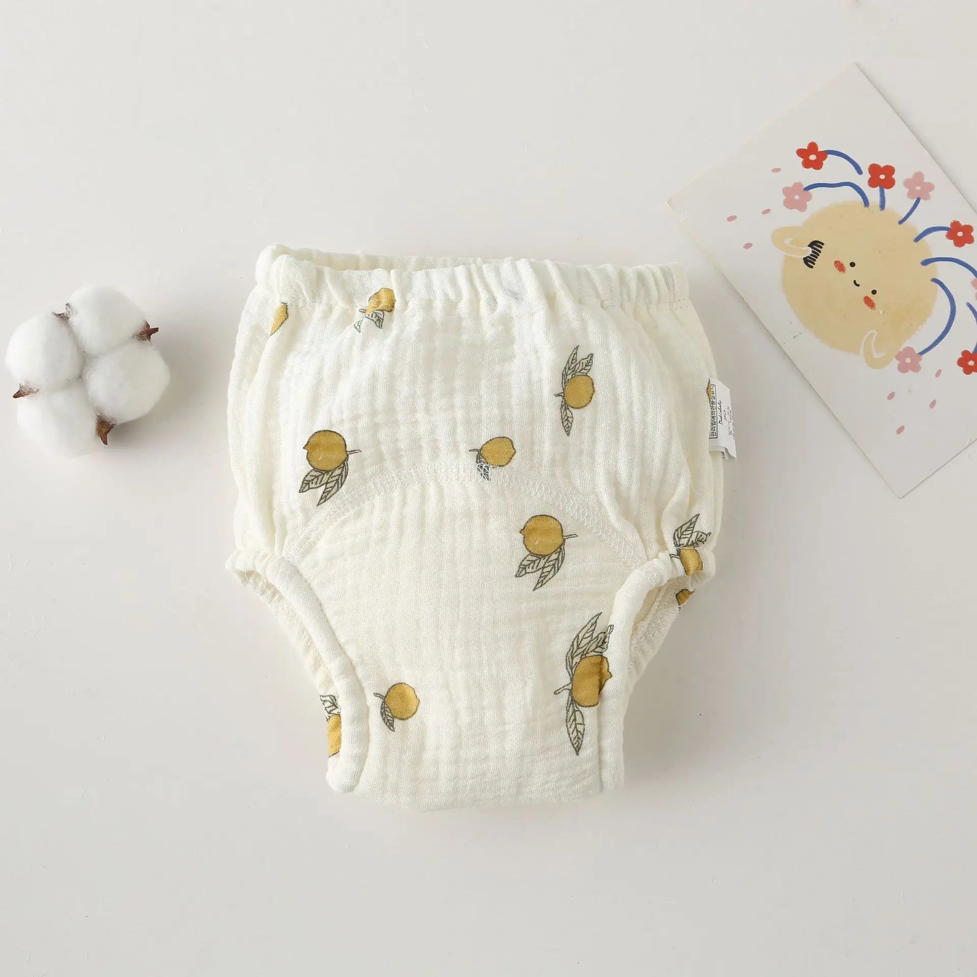 Baby care cloth diaper with lemon print on white muslin fabric. Comfortable cotton training pants for toddlers.