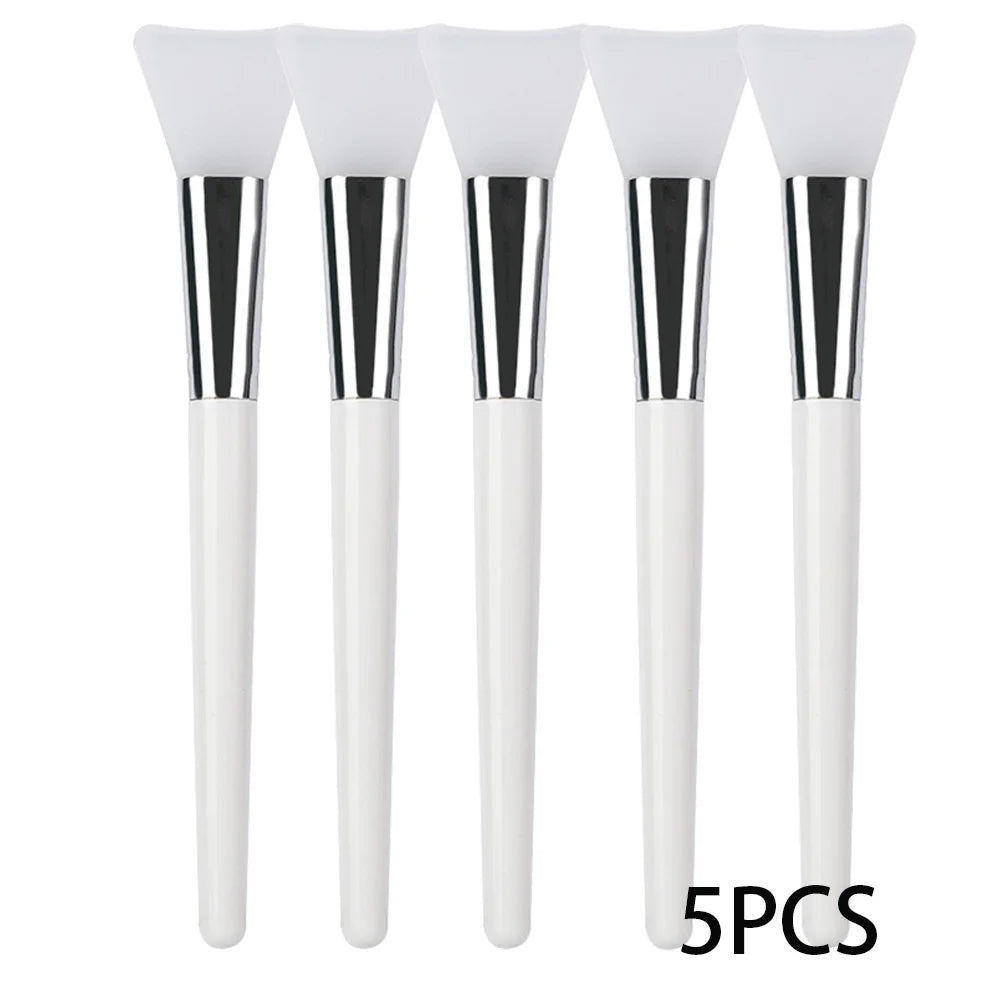 Five white silicone face mask applicator brushes with silver ferrules and white handles.