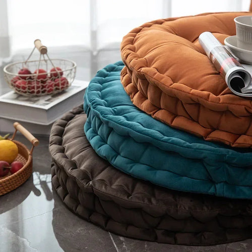 Round velvet meditation cushions in orange, teal, and brown for mindful zen practice and comfortable floor seating.