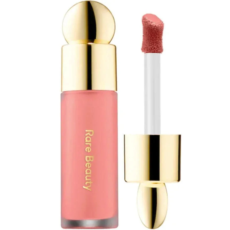 Rare Beauty soft pink liquid blush with gold cap and doe-foot applicator for lips and cheeks. Waterproof makeup.
