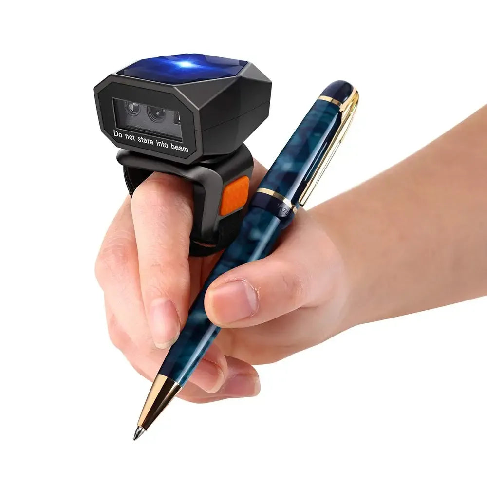 Black wearable ring barcode scanner with orange button, shown being worn on finger