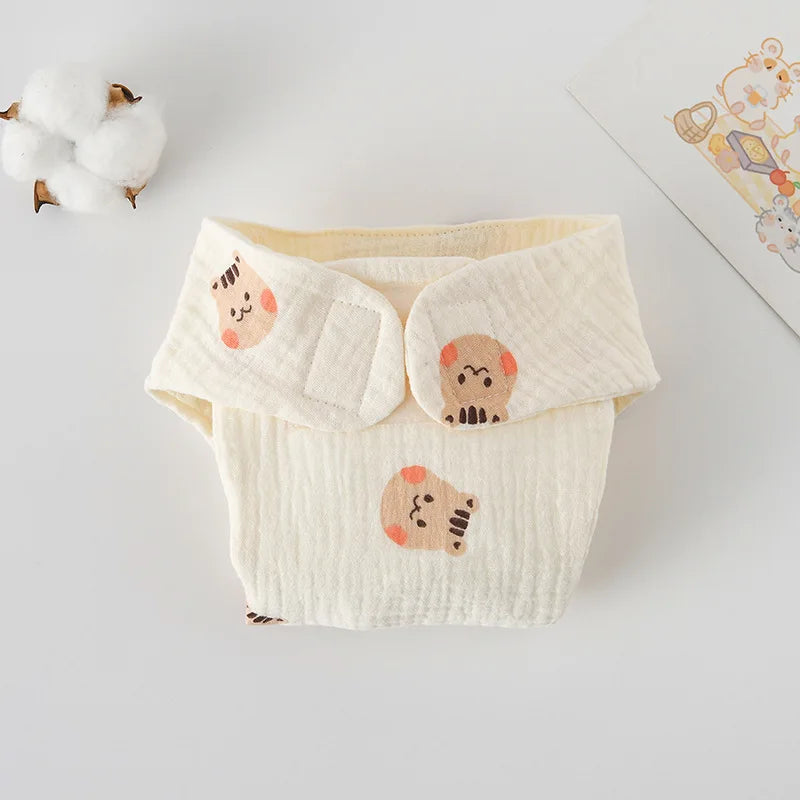 Cream-colored cotton baby diaper with cute bear print and velcro closures for gentle baby care.