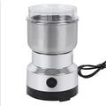 Compact stainless steel electric coffee bean grinder with clear lid and single-button operation on a black base.
