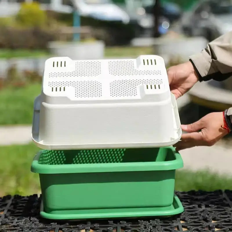 Rectangular plastic planter set with perforated insert and green base tray, held outdoors