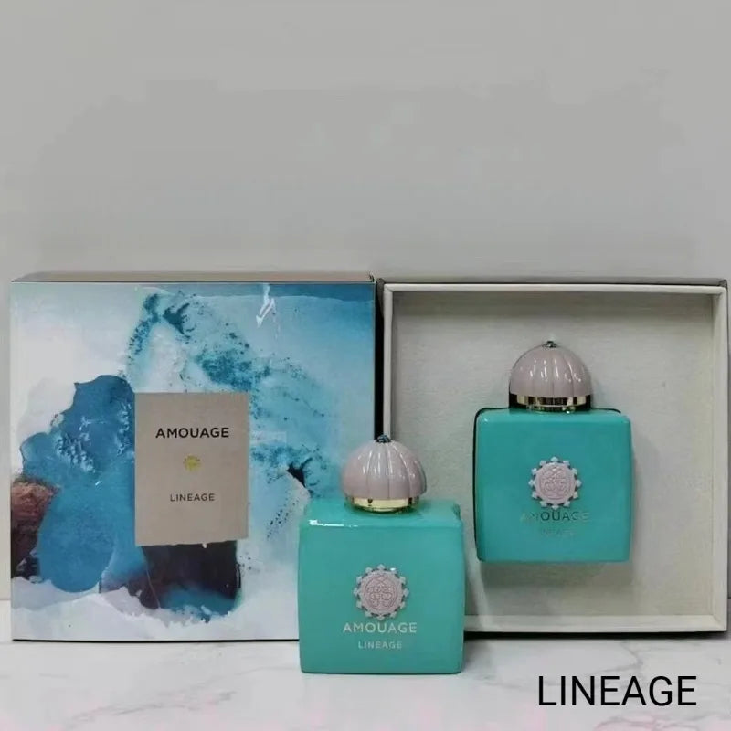 Two square turquoise perfume bottles with grey dome caps and decorative emblems, alongside an illustrated gift box.